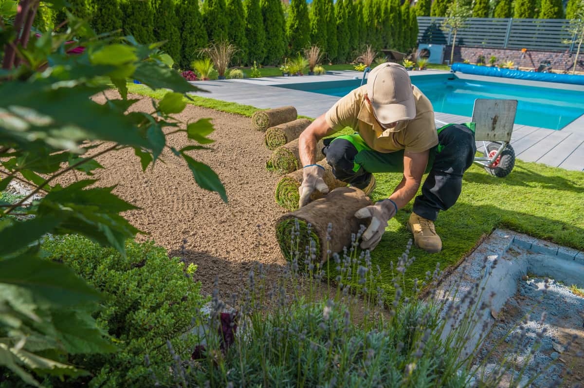 Professional contractor laying pavers on a patio, showcasing expert hardscaping work.