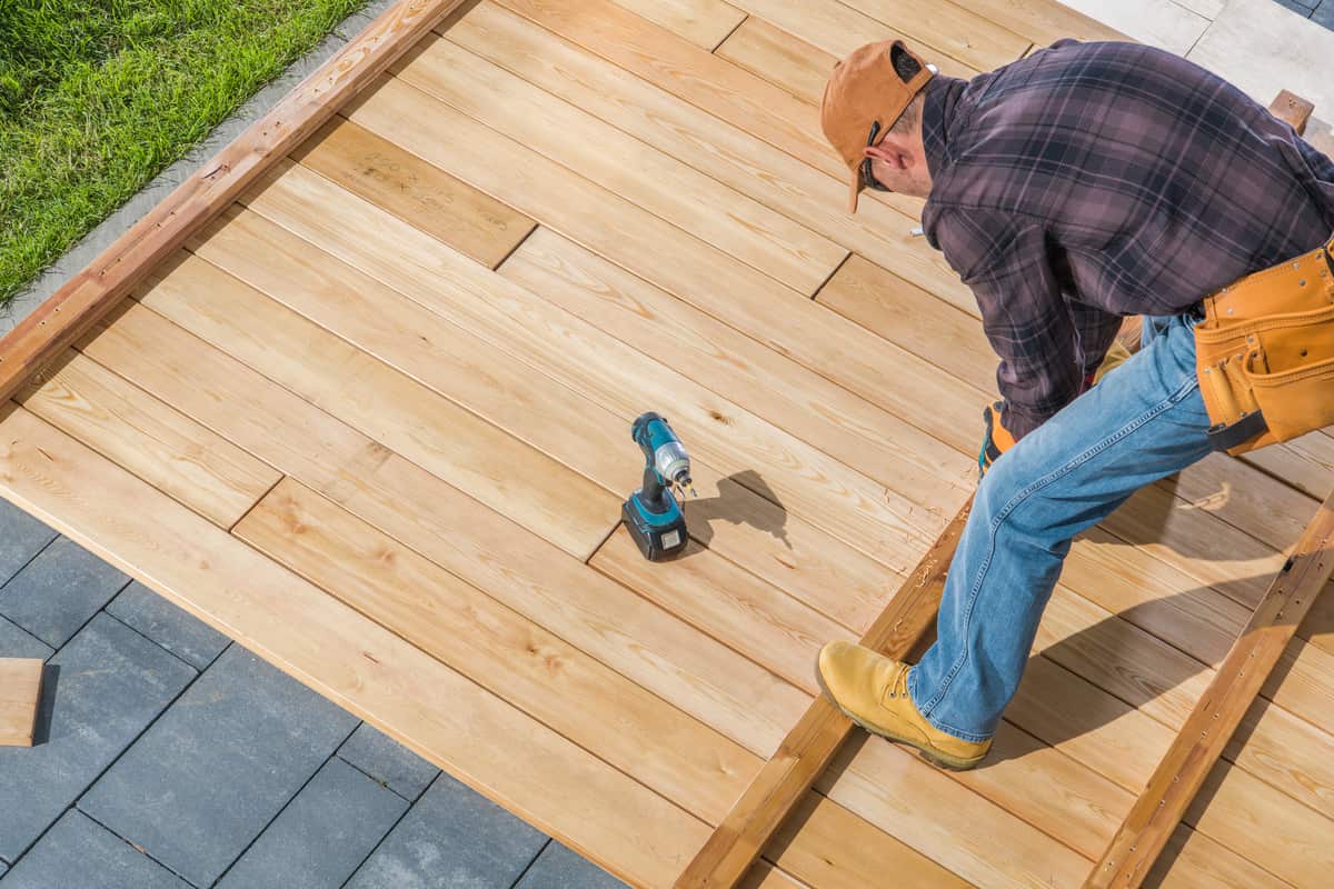 Men building a wooden deck in a backyard as part of Lee's Landscaping services